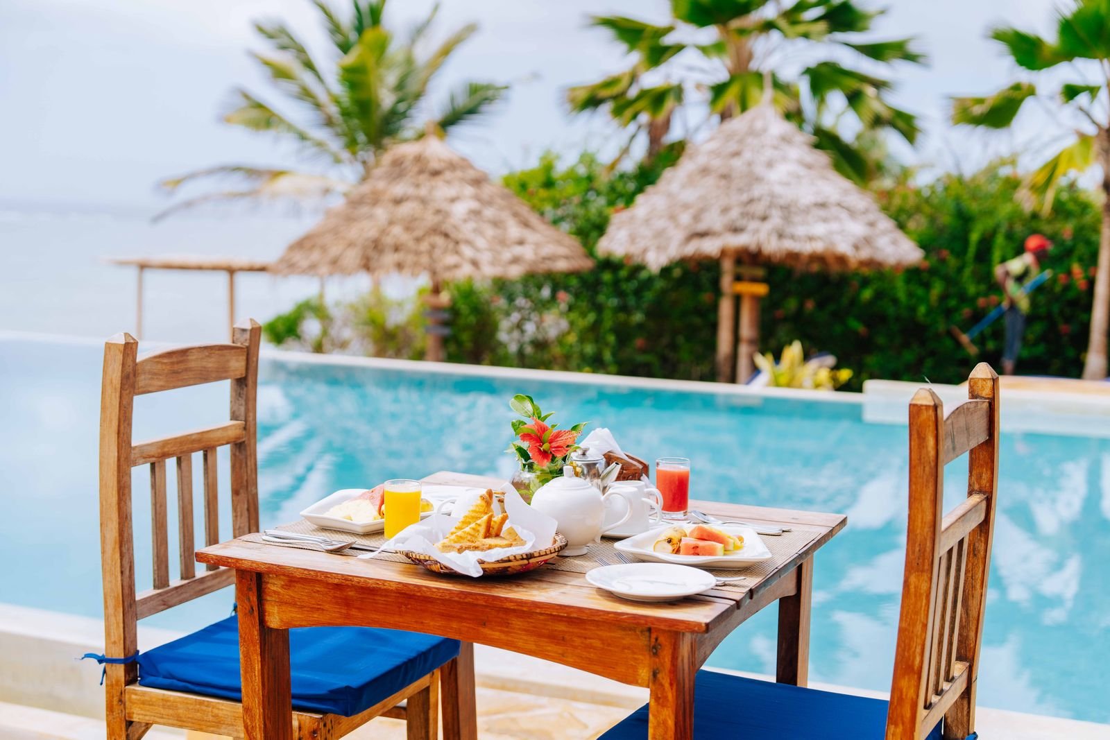 Breakfast table set beside the swimming pool with sea views