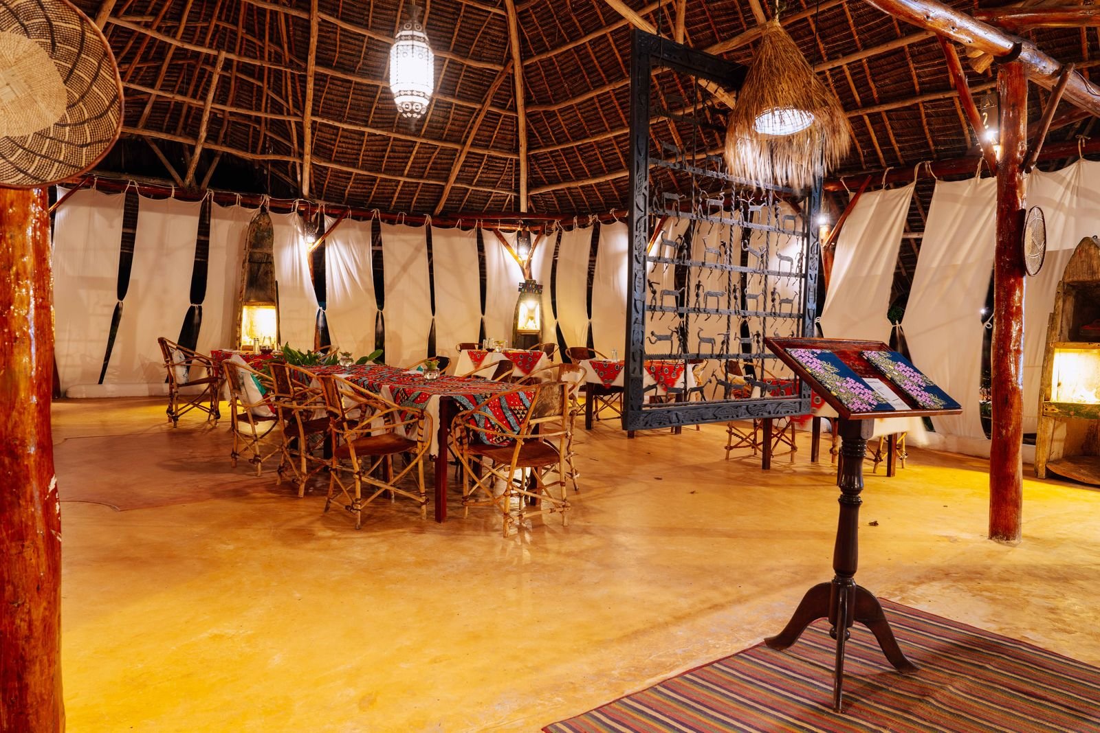 Sama Restaurant under its thatched roof, with candle lanterns and Swahili decor