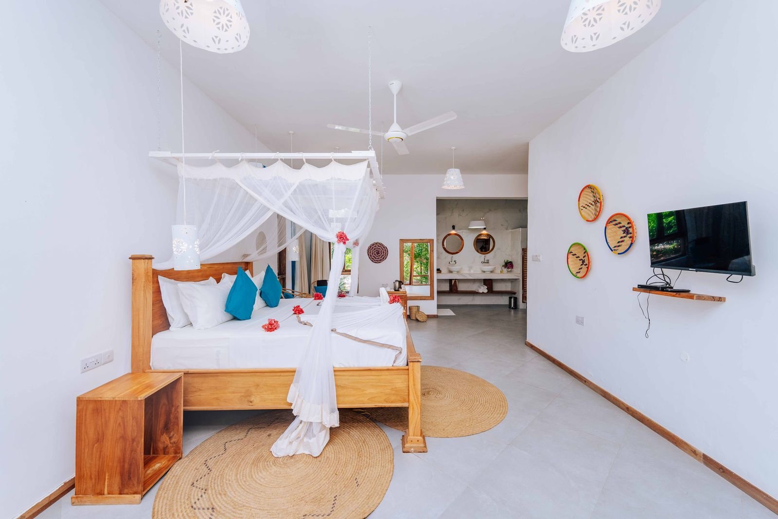 Bright Garden Room with a canopy bed, woven rug and Swahili wall decor