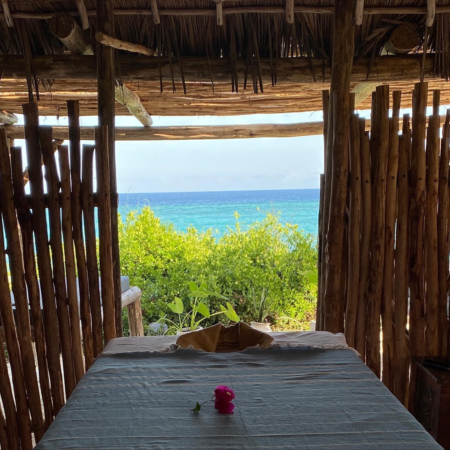 Open-air spa treatment room framed in wood with a view of the sea